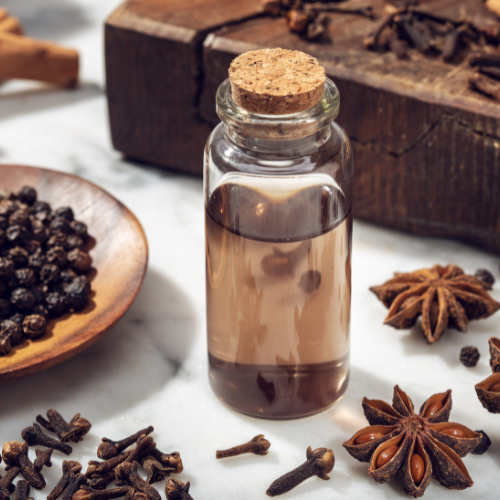 Glass bottle with savoury flavour blend alongside earthy or spicy ingredients.