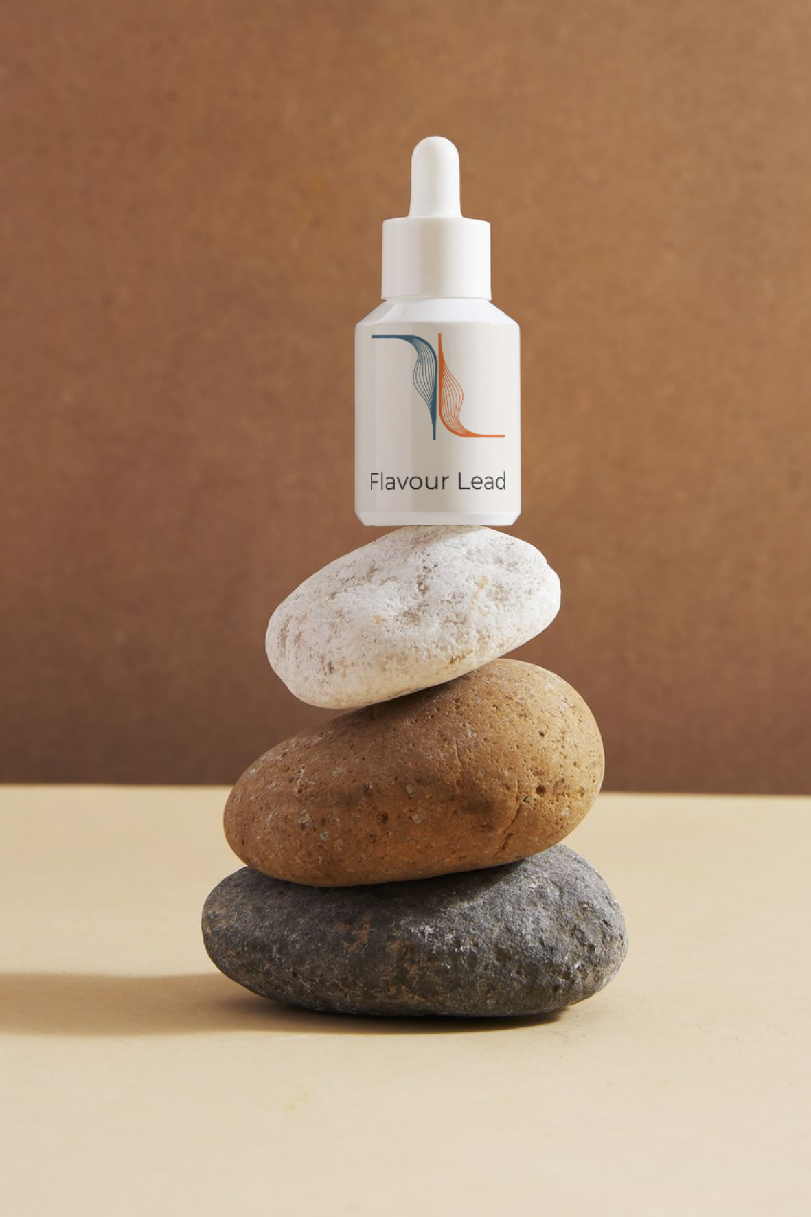 Small Flavour Lead amber bottle balanced on stacked stones, symbolising craft and balance in flavour blending.